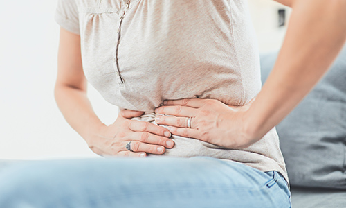 おなかを押さえている人の画像